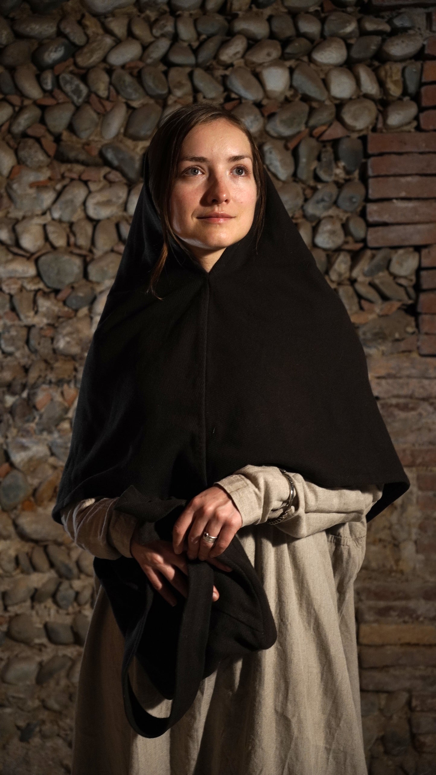 Woman wearing Roman hood holding a bag