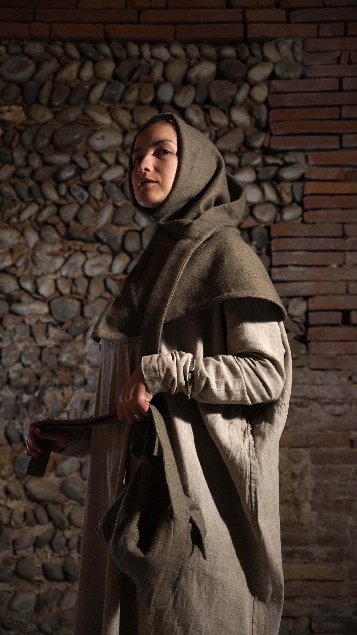 Woman wearing Bocksten hood holding a bag