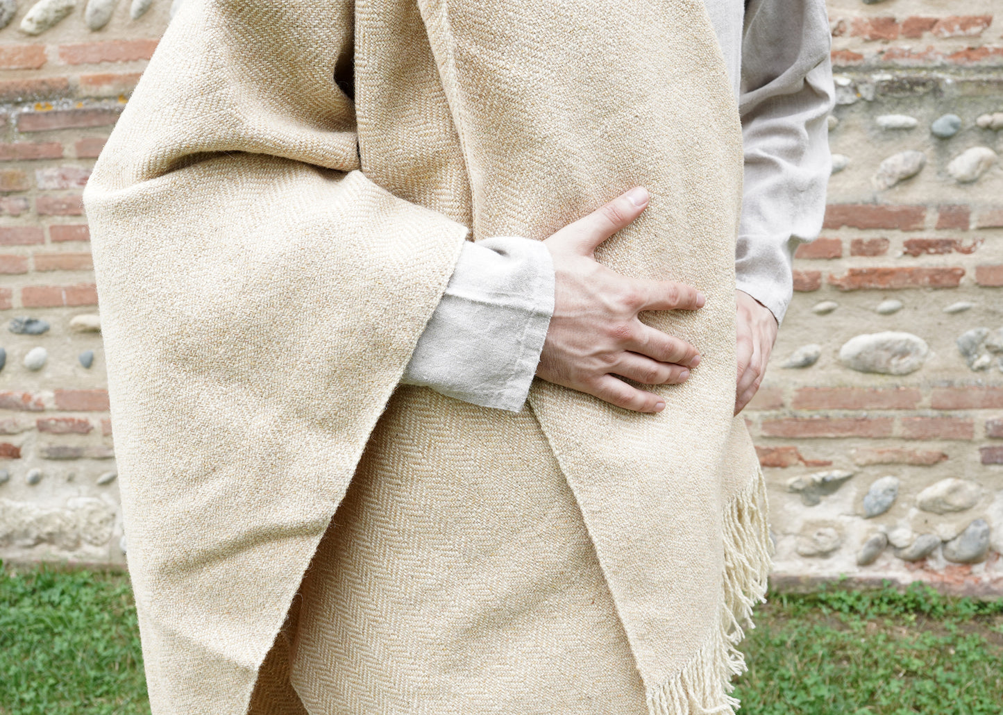 man dressed with Handwoven Herringbone Twill Cloak on tunik held by hand