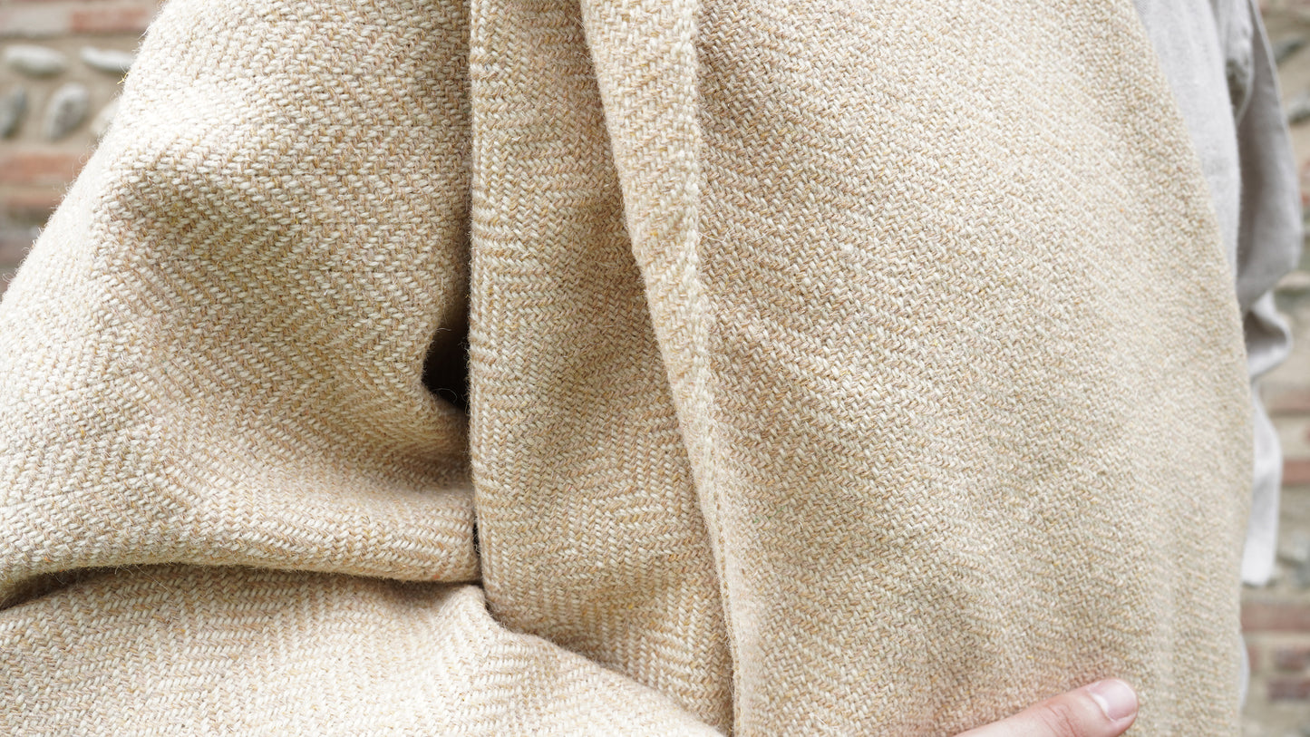 man dressed with Handwoven Herringbone Twill Cloak held by hand closeup view