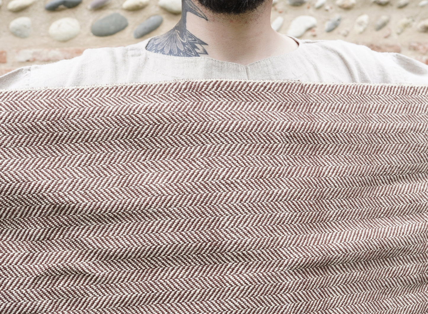 Handwoven Herringbone Twill Cloak held by man behind closeup pattern